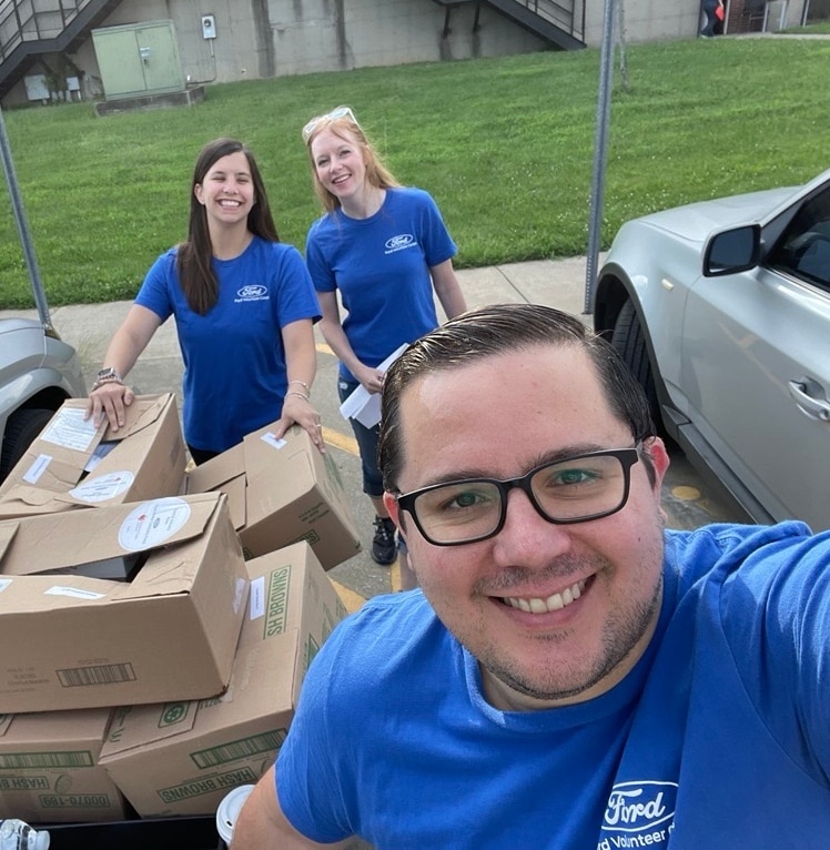 Alex Buznego, senior manager of mobility programs at Ford Philanthropy, helps load up donations as part of Project DASH.